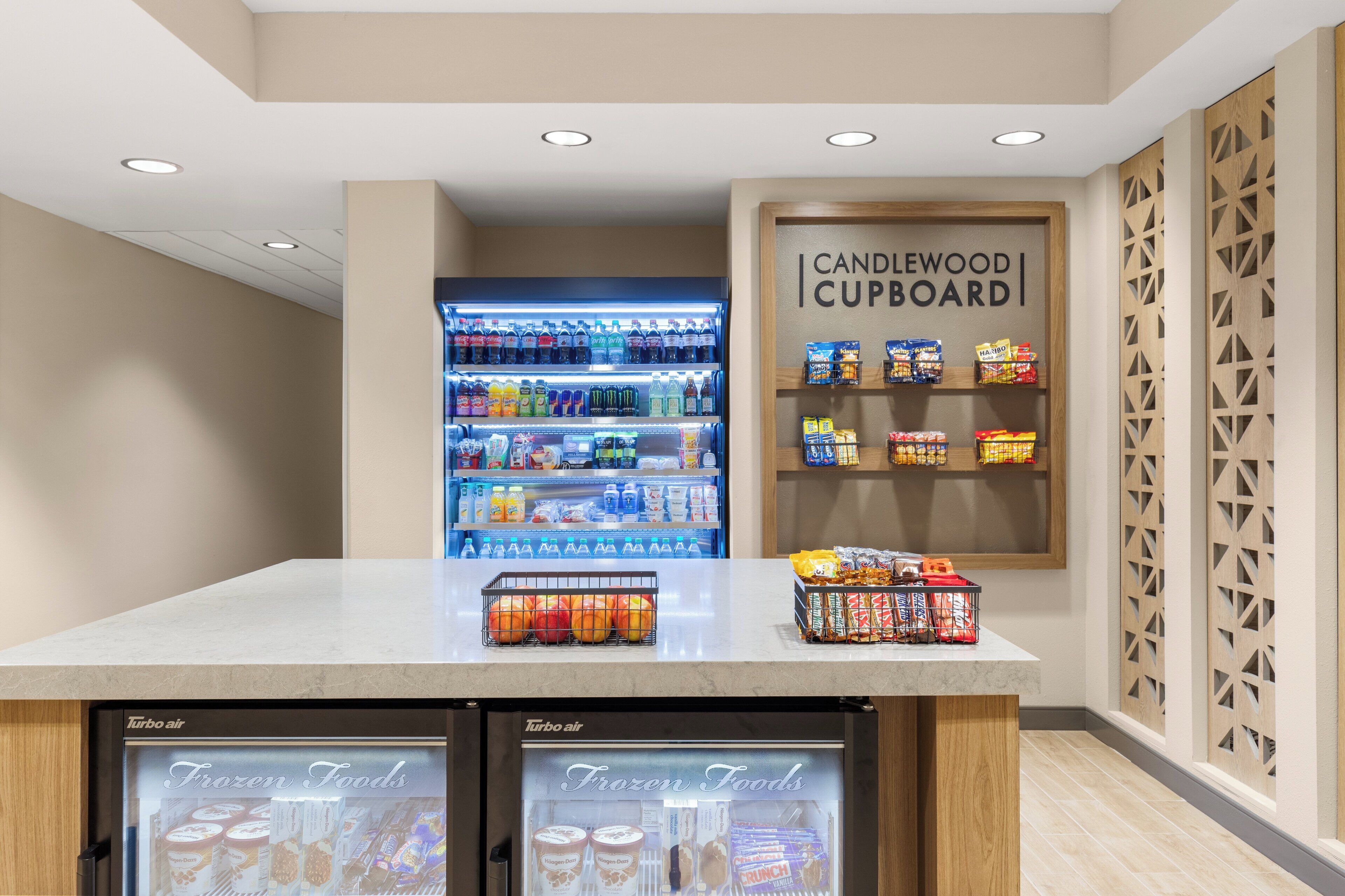 Un espace de libre-service où l’on peut se servir des boissons, avec une section réfrigérée pour les aliments surgelés et un présentoir pour les en-cas.