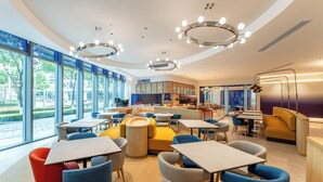 A modern restaurant with a curved ceiling, large windows, and a central bar area. - Holiday Inn Express Shanghai Hongqiao CBD by IHG (Shanghai)