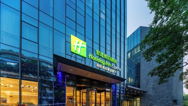 A modern hotel with a glass facade and a prominent sign for Holiday Inn Express. - Holiday Inn Express Shanghai Hongqiao CBD by IHG (Shanghai)