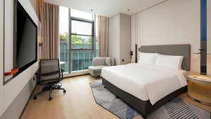 A modern hotel room with a large bed, a desk with a chair, a TV, and a window with curtains. - Holiday Inn Express Shanghai Hongqiao CBD by IHG (Shanghai)