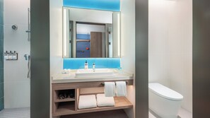 A modern bathroom with a large mirror, a sink, and a toilet. There are towels and toiletries on the counter. - Holiday Inn Express Xi An Caotang Technology Park by IHG (Xi'an)