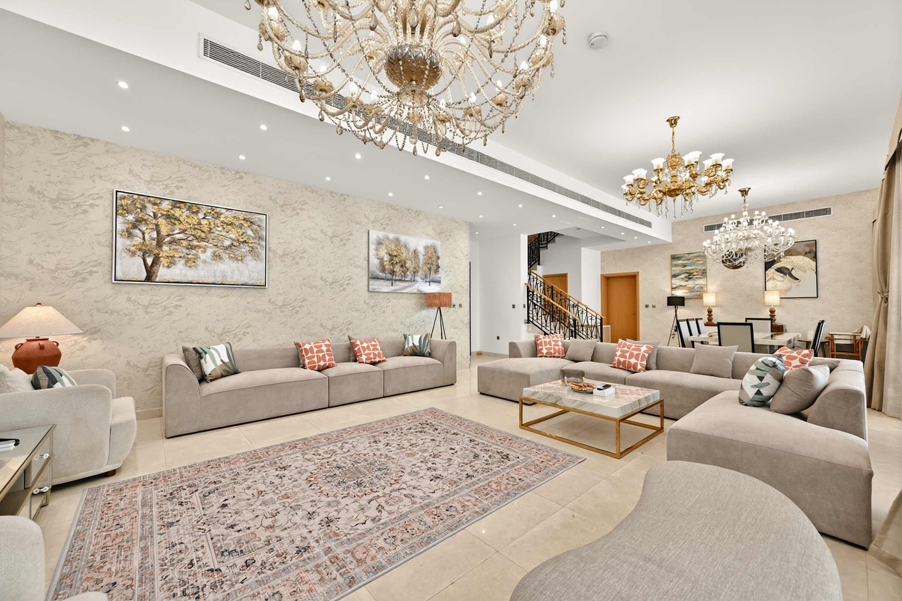 A spacious living room with two sofas, a coffee table, and a chandelier.