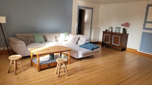 Ein Wohnzimmer mit einer Couch, einem Couchtisch, zwei Hocker und einem Schrank.