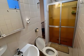 A bathroom with a toilet, sink, and shower area. - Cobertura Duplex no Guarujá SP - 4 (Guaruja)