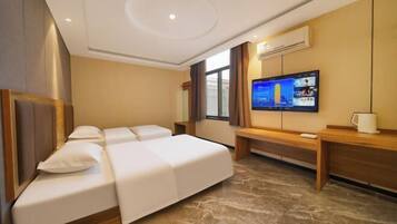 Een hotelkamer met een bed, een televisie, een bureau en een raam.