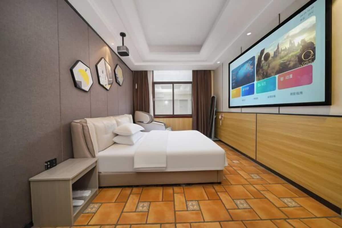 Habitación de hotel con cama, televisor y ventana.