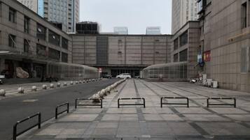 A wide pedestrian walkway leading to a building with a large entrance.