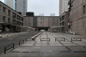 A wide pedestrian walkway leading to a building with a large entrance. - Jiayuan Business Hotel (Zhengzhou CBD Exhibition Center) (Zhengzhou)
