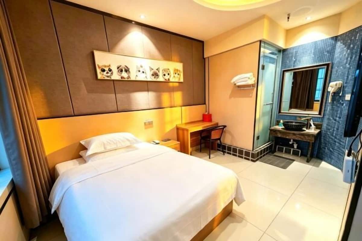 Una habitación de hotel con cama, escritorio y baño.