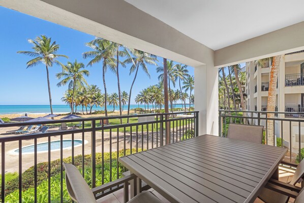 Un balcon avec vue sur la plage et les palmiers.
