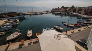 Un puerto deportivo con varias embarcaciones amarradas, cielo despejado y edificios al fondo.
