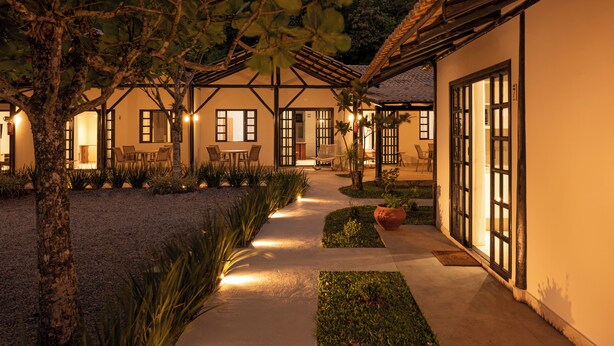 A courtyard with a dining area, outdoor seating, and a pathway leading to the entrance. - SUNSET PORTO BELO locaçoes (Porto Belo)