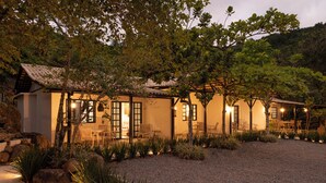 A traditional-style building with multiple rooms, outdoor seating, and a gravel driveway. - SUNSET PORTO BELO locaçoes (Porto Belo)