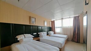 A hotel room with three single beds, a headboard, a window with curtains, and a framed picture on the wall. - Shanghai Maoyi Hotel (Shanghai)