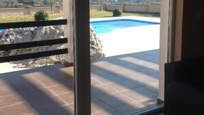 Une vue depuis un balcon donnant sur une piscine et un paysage montagneux.