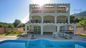 A two-story building with a swimming pool in front.