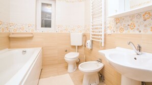 A bathroom with a bathtub, toilet, bidet, and sink. - Comfortable Stay with Sea View in Petrovac - Studio with External Bathroom 2 (Petrovac na Moru)