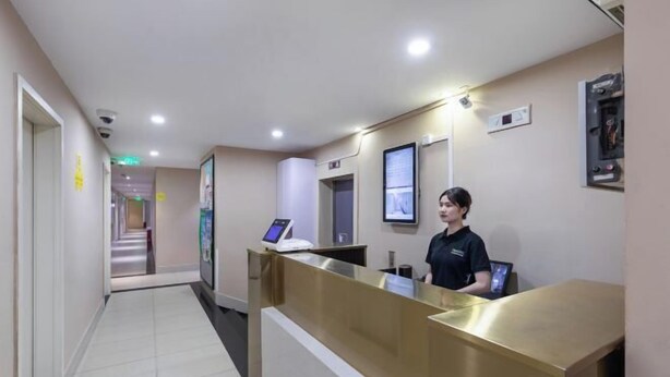 A hotel reception area with a reception desk, a security camera, and a digital display. - 100 Inn (Shanghai Pudong Jinqiao) (Shanghai)