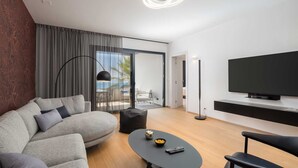 A modern living room with a sofa, coffee table, and a flat-screen TV.
