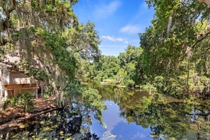 Una vista tranquila del río con una cabaña de madera y abundante vegetación.