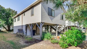 A two-story house with a covered porch and a small garden area. - Close to Coastal Beaches & Bay Side to Sound (Kill Devil Hills)