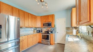 A kitchen with wooden cabinets, stainless steel appliances, and a granite countertop. - Private Deck & Views: Rural Virginia Escape (Gordonsville)