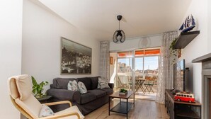 Een moderne woonkamer met een bank, een fauteuil, een salontafel en een open haard.