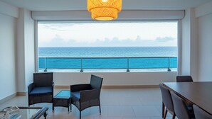 A balcony with a view of the ocean, furnished with two chairs and a table. - Enjoy the Wonderful Ocean & Pool View from This 2BDR Apartment in Juan Dolio (Guayacanes)