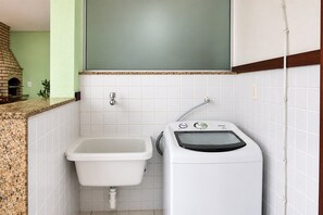 A bathroom with a sink, a washing machine, and a tiled wall. - Bz08 Casa 200m da praia de Geribá (Buzios)