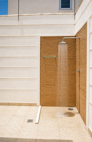 A shower area with a wooden panel wall, a metal showerhead, and a tiled floor. - Bz08 Casa 200m da praia de Geribá (Buzios)
