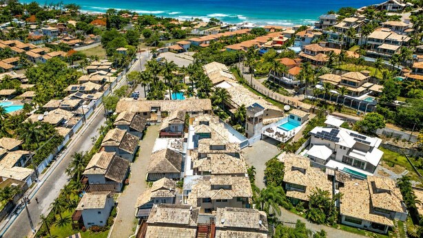 A coastal residential area with houses, a swimming pool, and a view of the ocean.