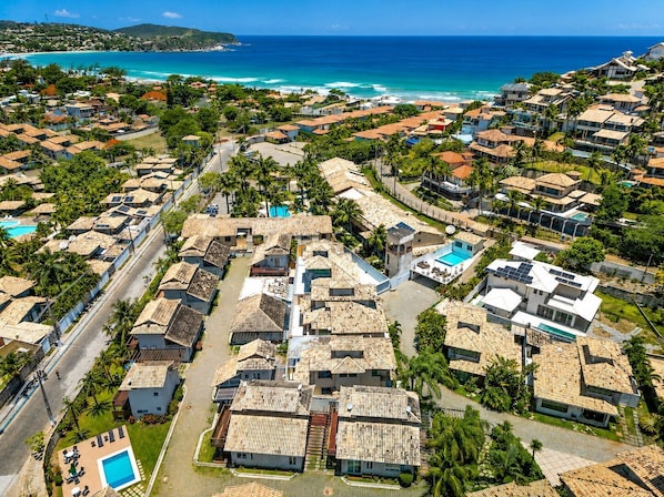 Un área residencial costera con casas, una piscina y vista al océano.