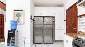 A kitchen with white cabinets, stainless steel appliances, and a water dispenser.