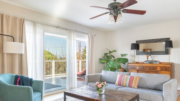 Un salon comprenant un canapé, un fauteuil, une table basse et un ventilateur de plafond.