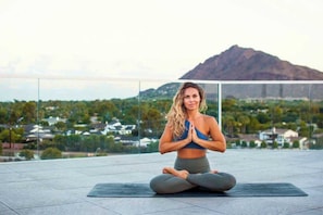 A person sitting on a yoga mat outdoors with a mountain in the background. - Escape in the Heart of Old Town Scottsdale AZ (Scottsdale)