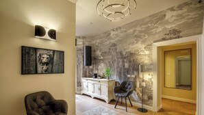 Una sala de estar moderna con chimenea, un comedor con un aparador blanco y un espejo grande.