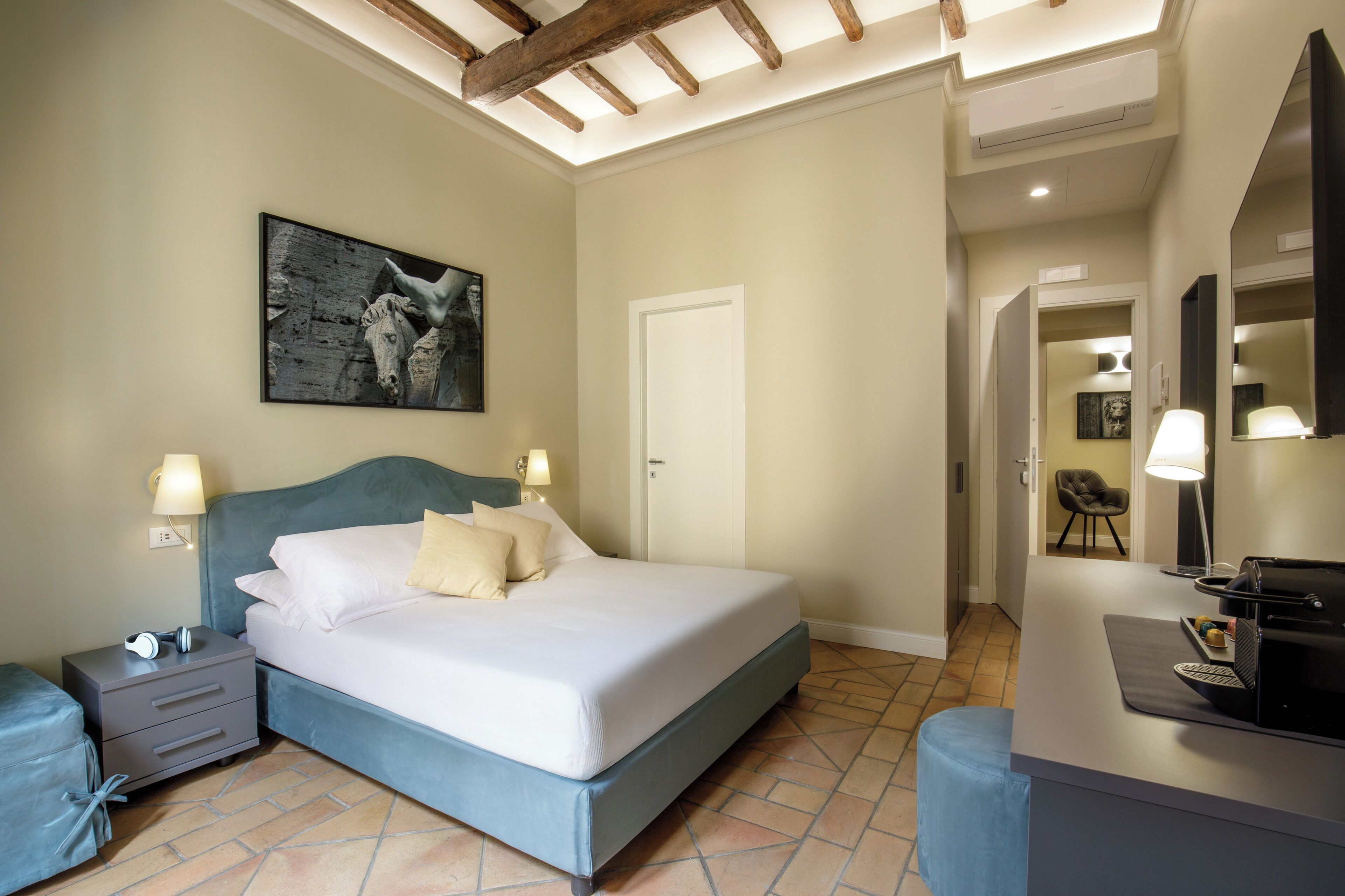 A bedroom with a bed, bedside tables, a desk, and a chair.