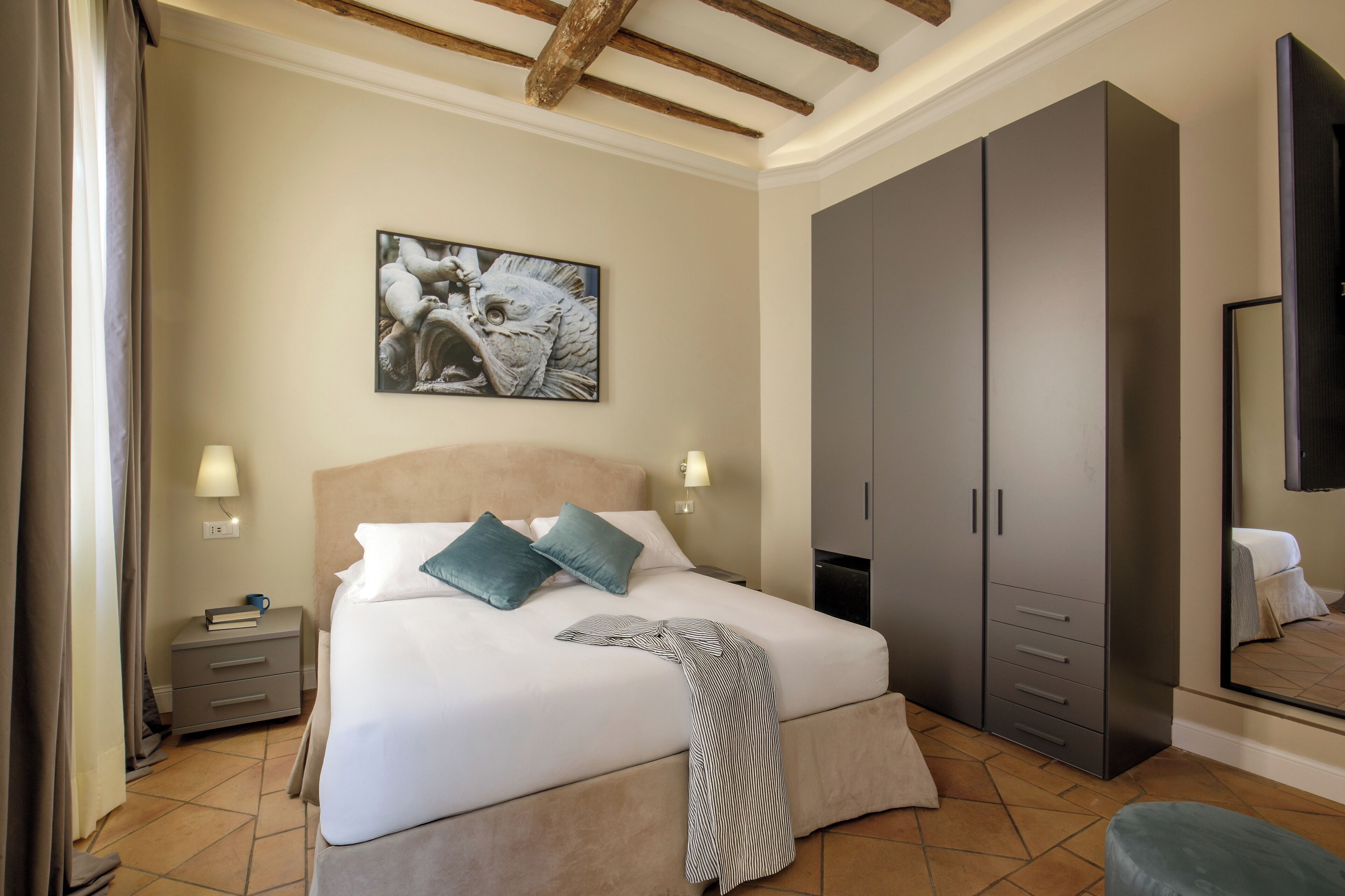 A bedroom with a bed, nightstands, a wardrobe, a painting, and a mirror.