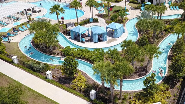 A resort with a large swimming pool, palm trees, and lounge areas. - 8941- Great Family Home near Disney, private pool - Windsor at Westside Resort (Kissimmee)