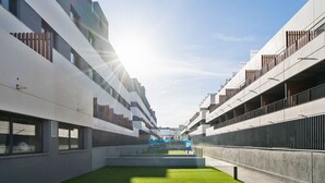 A modern building with a central courtyard, large windows, and balconies. - apartamento reformado con garaje de alquiler temporal (San Sebastián de los Reyes)