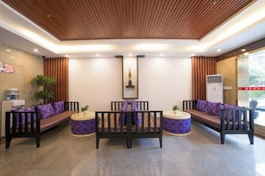 A reception area with a wooden ceiling, seating arrangements, and a large window. - Xinguolv Hotel (Wenchuan)