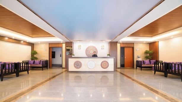 Um hall amplo com balcão de recepção, áreas de estar e piso lustroso.