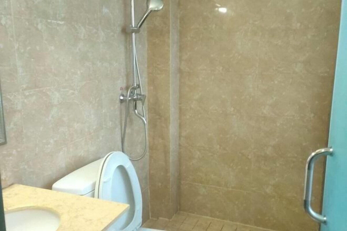 A bathroom with a toilet, a shower, and a sink.