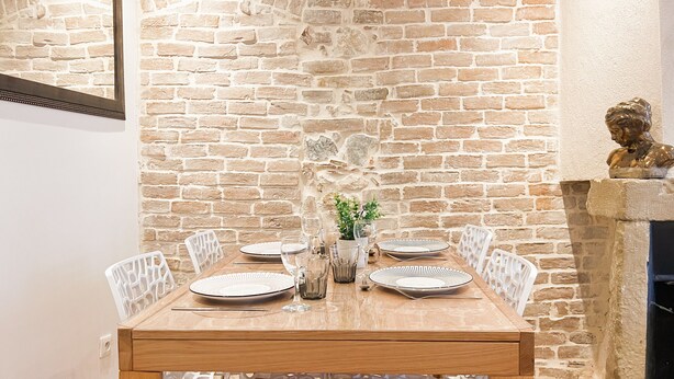 A dining table set with plates, glasses, and a vase with flowers. - Harmonie en plein cœur du Vieil Annecy (Annecy)