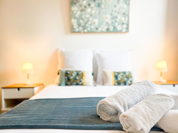 Tabla de planchar con plancha y ropa de cama