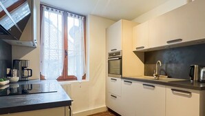 A compact kitchen with a built-in oven, a coffee machine, and a sink. - Harmonie en plein cœur du Vieil Annecy (Annecy)