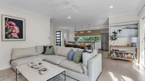 A modern living room with a sofa, coffee table, and a bookshelf. - Sunshine on Saltwater (Kingscliff)