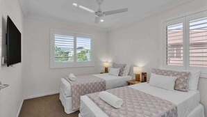A hotel room with two beds, a ceiling fan, a TV, and a window with blinds. - Sunshine on Saltwater (Kingscliff)