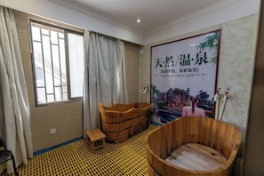 A room with a large window, wooden tubs, a small stool, and a poster on the wall. - New Fali Hotel (Lianjiang)