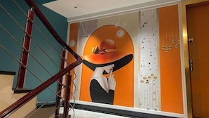 A staircase with a handrail and a wall with a large mural. - New Fali Hotel (Lianjiang)